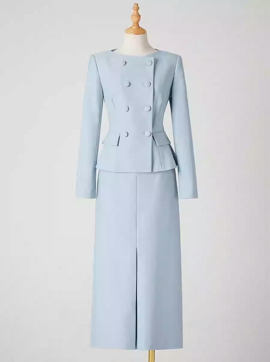 A Woman Dressed In An Elegant Light Blue Suit Leans Against A Table In A Cozy Café Setting before